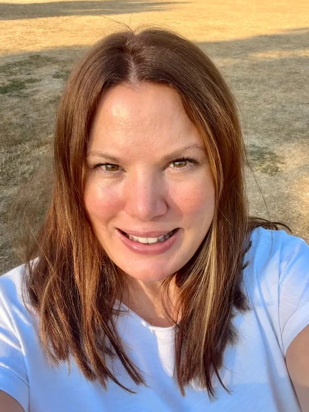 Rebecca Griffiths in a white top, in a sunny field