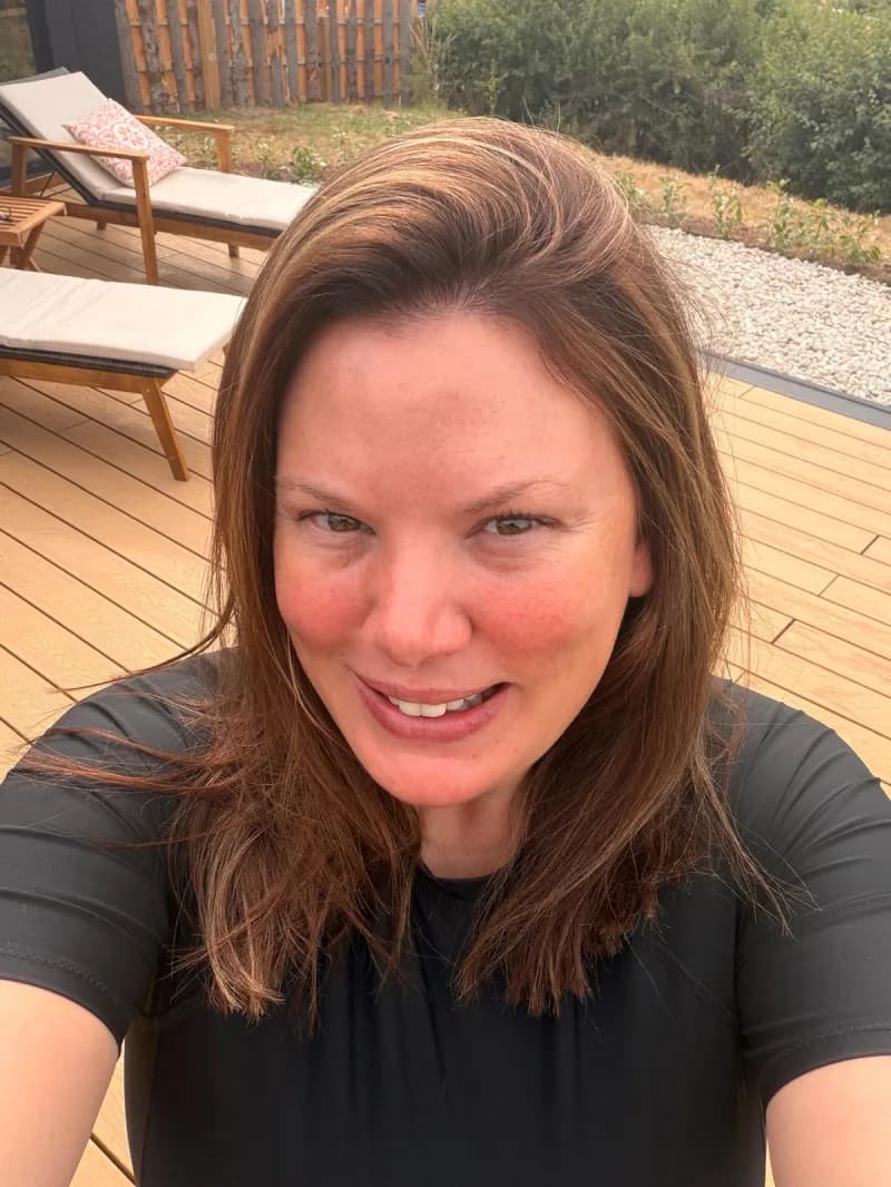 Rebecca on a deck with sun loungers, her hair wet